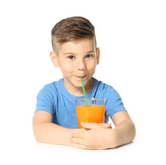 Cute little boy drinking juice on white background