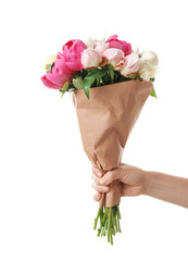 Female hand with bouquet of beautiful peony flowers on white background