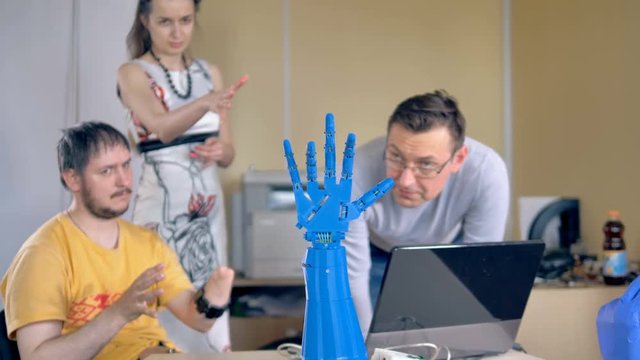 Disabled man controls bionic hand using wireless sensors on his amputated hand.