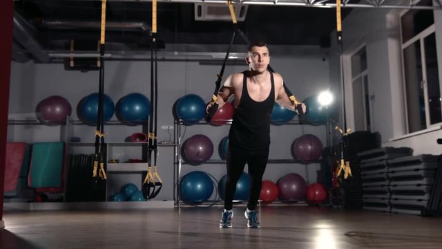 Man exercise at a gym by using bungee training