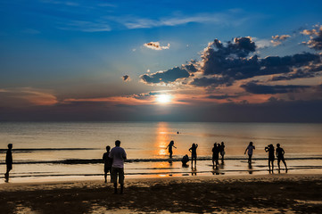 people on the beach at the sunset time.friendly and family on the beach concept.