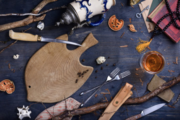Wooden table with cooking ingredients, fish cutting board, top view.