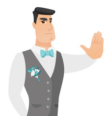Young caucasian groom showing stop hand gesture.
