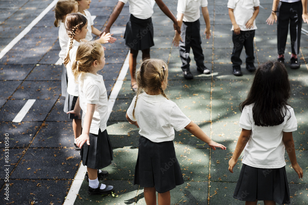 Wall mural group of diverse kindergarten students standing holding hands together