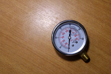 Air pressure gauge on wooden background. 
