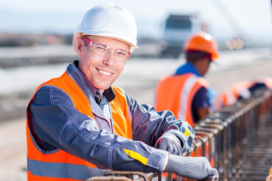 Worker Fixing Steel Rebar At Building Site