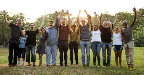 Group of people holding arms raised in the park