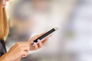 Young asian woman using smartphone on blur background.
