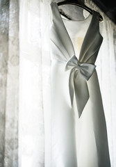 White Wedding Dress Hanging by the Window