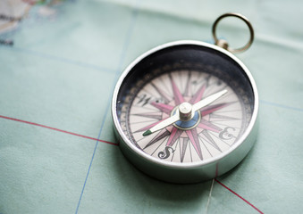 Closeup of metallic compass on the map journey planning