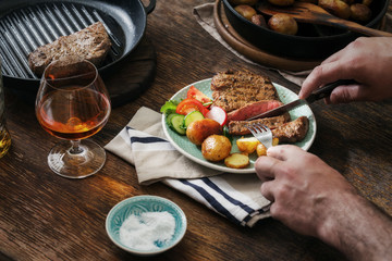 Man is eating dinner at a wooden table