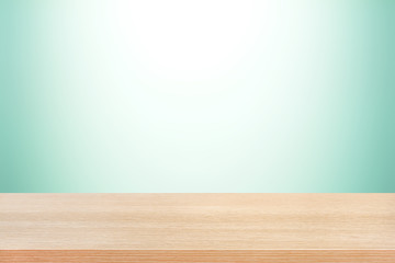 Wood table top on light green gradient background