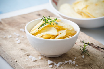 Potato chips in a bowl on wooden background