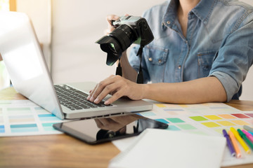 Photography Ideas Creative Occupation Design Studio Concept, Female photographer sitting on the desk with laptop