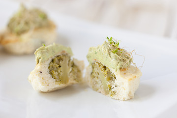 Mini cauliflower casseroles with avocado cream on a white plate