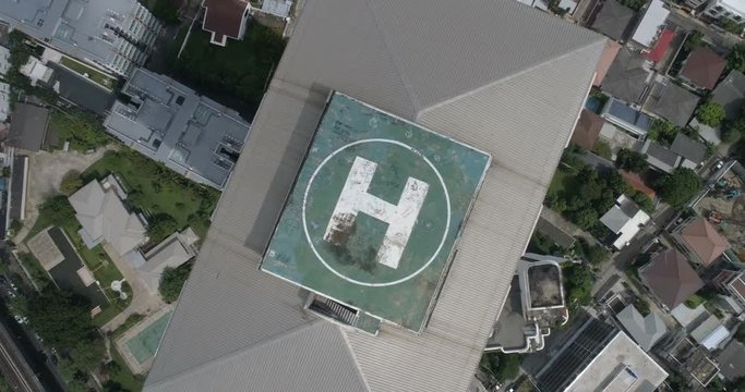 Aerial drone view of helipad isolated on top of the skycraper in Bangkok city during cloudy day
