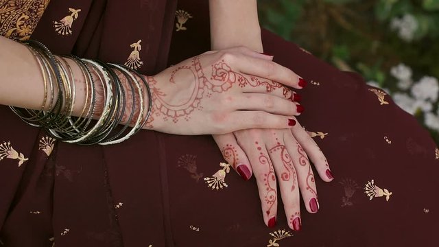 Close-up of Indian bride's hands covered with mehndi. Indian wedding ceremony. Mehendi hand. Mehndi covers Indian bride's hands with bracelets.