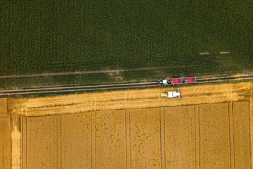 Aerial view of combine harvester unloading harvested wheat © Bits and Splits