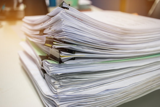Stack of paper files on work desk in office