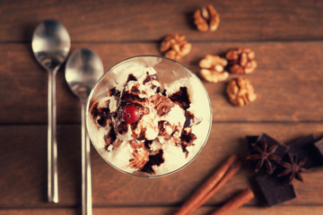 Ice cream sundae, chocolate pieces, walnuts, spoons and spices