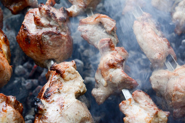 Marinated shashlik preparing on a barbecue grill over charcoal.