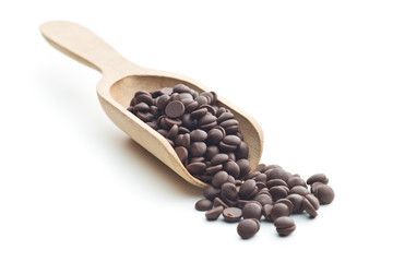 Tasty chocolate morsels in wooden scoop.