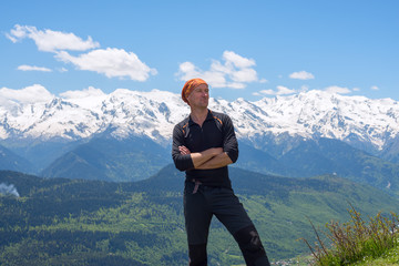 Fototapeta na wymiar Happy man adventurer stands on a mountains