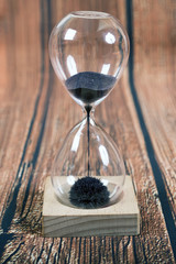 Hourglass, iron  sand on wooden background