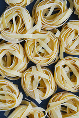 Top view on uncooked nests of tagliatelle pasta