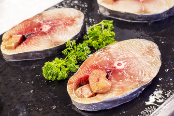 fresh scomberomorus fish placed on black slabs. In supermarket