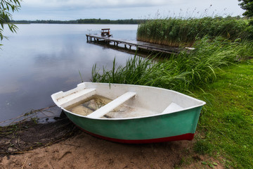 Obraz premium Fisherman's boat and bridge with fishing poles at Masuria lake, Poland