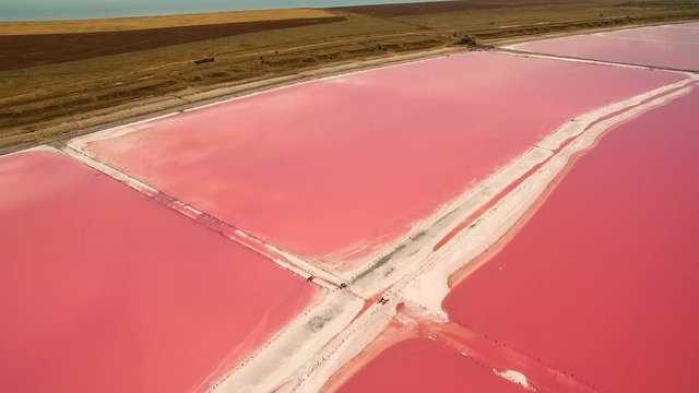 Aerial view of salt sea water evaporation ponds with pink plankton colour