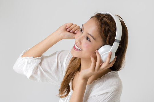 young latina listening a music with wireless headphone.