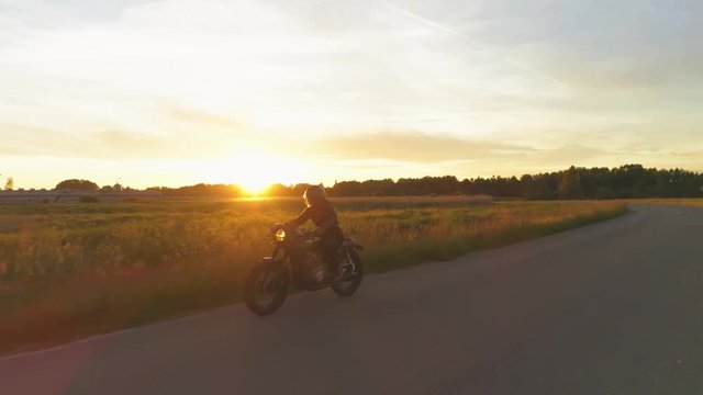 Riding vintage custom made cafe racer on a sunset