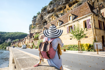Young woman tourist enjoying great view on the old buildings in La Roque Gageac village in France