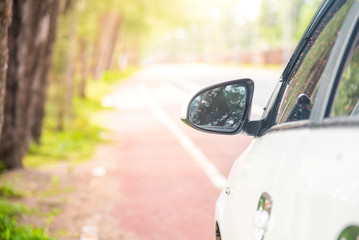 Naklejka premium side rear-view car mirror parking on the roadside.