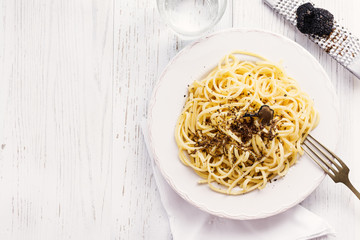 Strangozzi, italian wheat pasta with truffle on a light background.