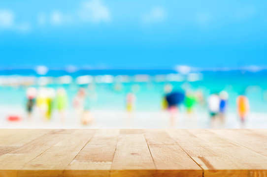 Wood table top with blurred people at the beach as background - can be used for display or montage your products
