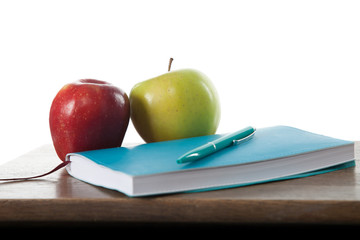 Turquoise notepad with pen, apples and cup.  Work and study environment. 