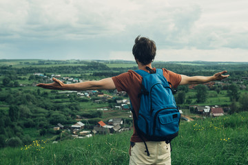 Fototapeta premium Happy tourist traveler standing with raised hands / hipster young man enjoy the view / background landscape view mockup