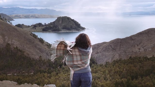 Bolivian woman contemplating beautiful panorama of the lake Titicaca.