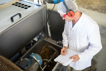 Technician examining processing machine