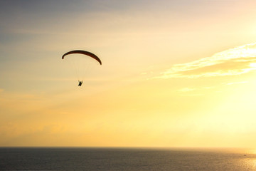 Silhouette of paraglider soaring over sea at sunset,Phuket,Thailand.