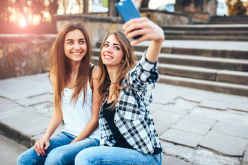 Two pretty girls making selfie in the park