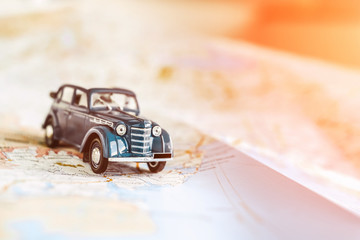 Toy retro cabrio car on the map, tourism concept