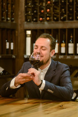 Young sommelier on red wine in cellar