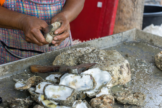 motion blur of hands shucking shell oyster