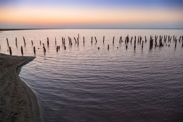 Fototapeta na wymiar Landscape of lake at dawn / Abandoned destroyed wooden pier on lake at dawn