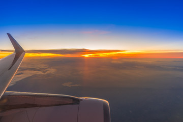 Fototapeta na wymiar Plane wing on the sky with sunset and cloud, aerial view from airplane window.