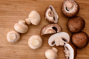 Gray mushrooms champignons lie on a wooden kitchen board